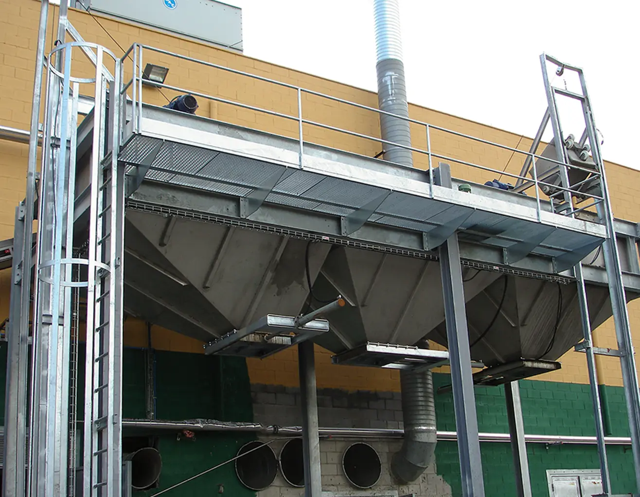 silos con elevador de caldereta con una escalera lateral para subir a plataforma con barandilla de seguridad